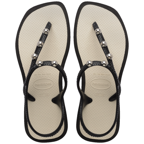 Chinelo preto com detalhes metálicos e sola bege, confortável e estiloso para uso diário.